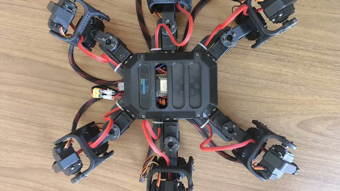 Hexapod seen from above: body cover with a window onto the controller board, six legs spread out.